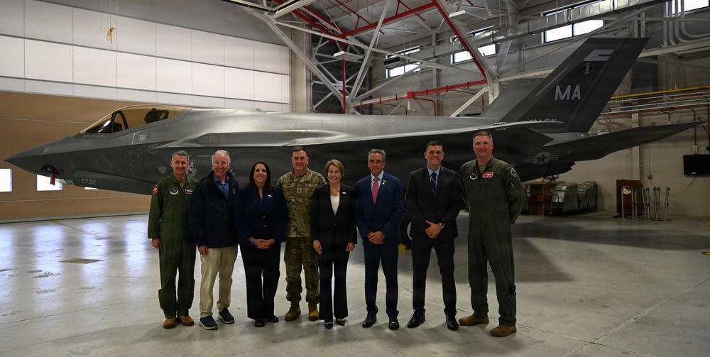 Officials and military leaders stand in front of an F-35A at Barnes Air National Guard Base during the 104th Fighter Wing's transition ceremony on 13 September 2026.