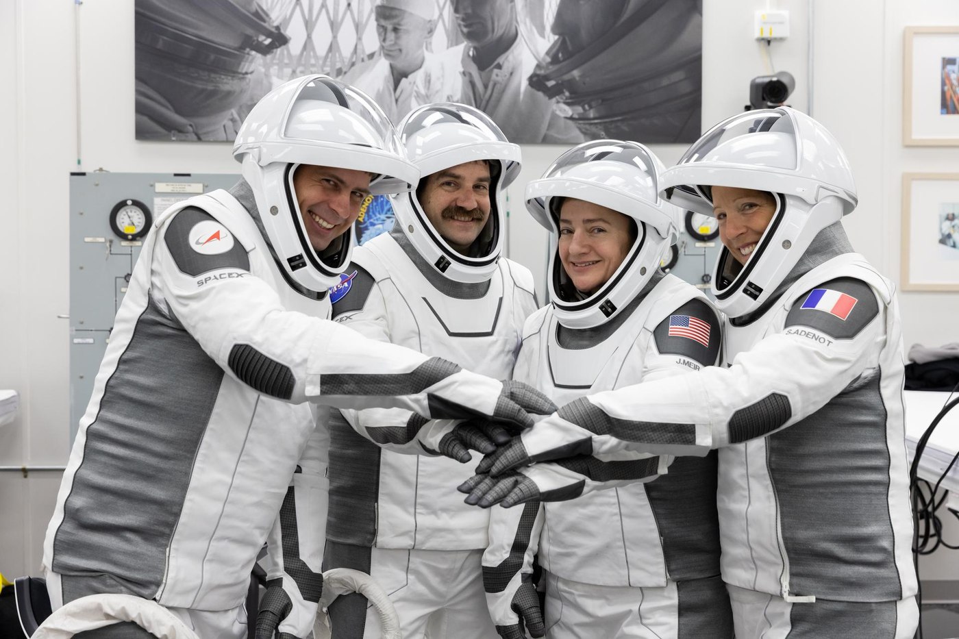 Crew-12 astronauts in spacesuits placing their hands together before their February 13, 2026 launch
